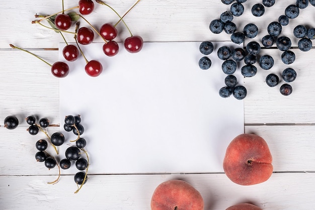 Frutas de verão em uma mesa branca pêssego nectarina mirtilo e groselha saudável café da manhã