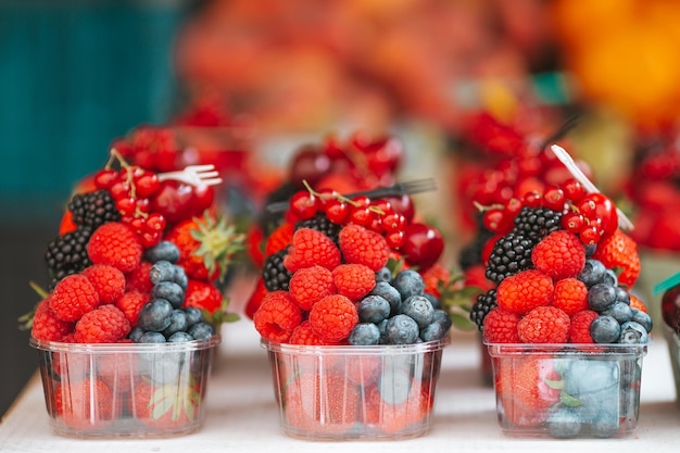 Frutas e bagas no mercado de rua Mirtilos framboesas morangos cerejas e amoras no mercado Jardinagem agricultura colheita e conceito de floresta