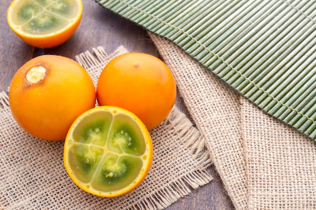 Frutas e fatias de lulo ou naranjilla na mesa de madeira Solanum quitoense