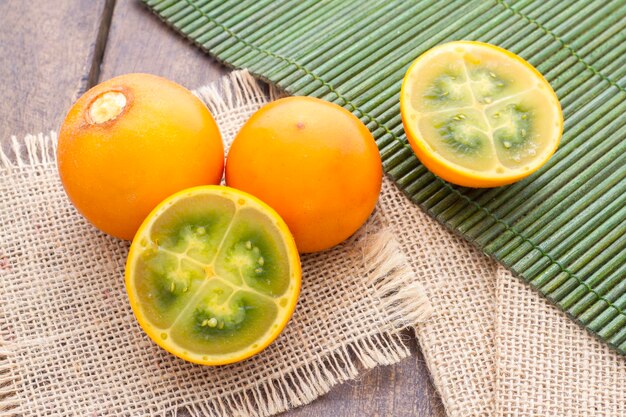 Frutas e fatias de lulo ou naranjilla na mesa de madeira Solanum quitoense