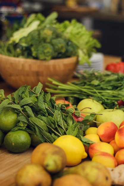 Frutas e legumes frescos em uma mesa de madeira.