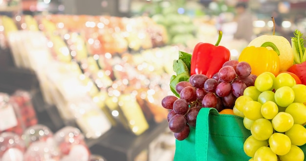 Frutas e legumes frescos na sacola de compras com fundo desfocado de supermercado