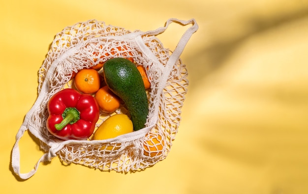 Frutas e vegetais orgânicos em uma sacola de compras de algodão de malha reutilizável e sem desperdício Sacola ecológica