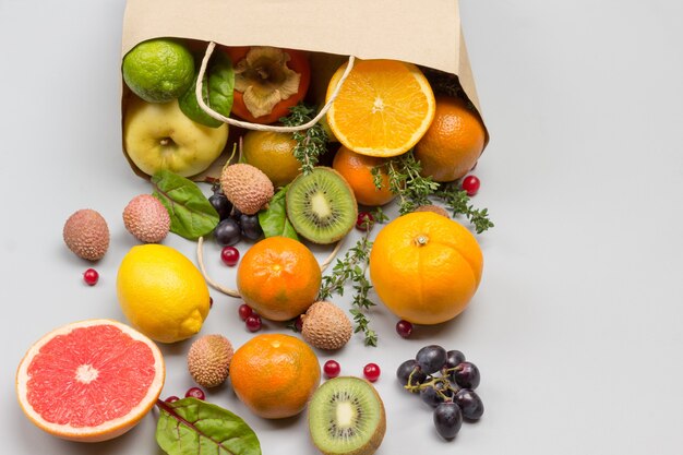 Frutas em saco de papel. caqui, kiwi e laranja na mesa