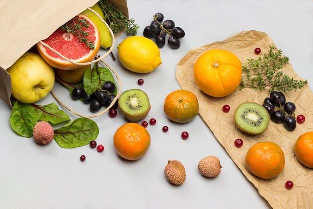 Foto frutas em sacos de papel persimmon kiwi e laranja na mesa