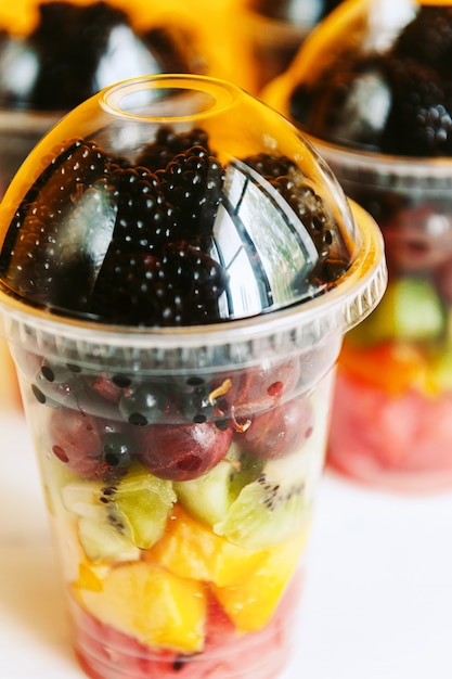 Frutas em um copo de plástico.