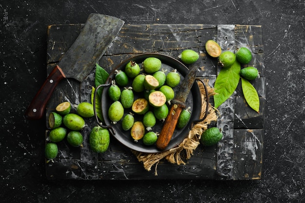 Frutas de feijoa o guayaba de piña frutas verdes exóticas Vista superior sobre un fondo de piedra negra