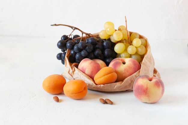 Frutas frescas en una bolsa de papel, concepto de desperdicio cero, comida sana, comida vegetariana, fondo blanco, vista lateral