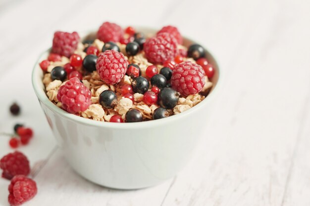 Frutas frescas coloridas com flocos em um copo branco