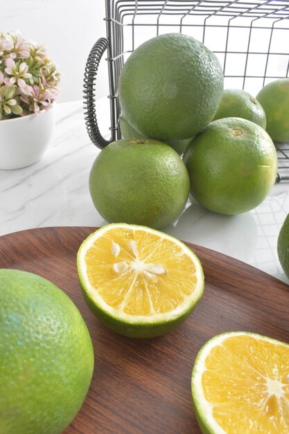 Frutas frescas de laranjas para bebês com casca verde em cima da mesa