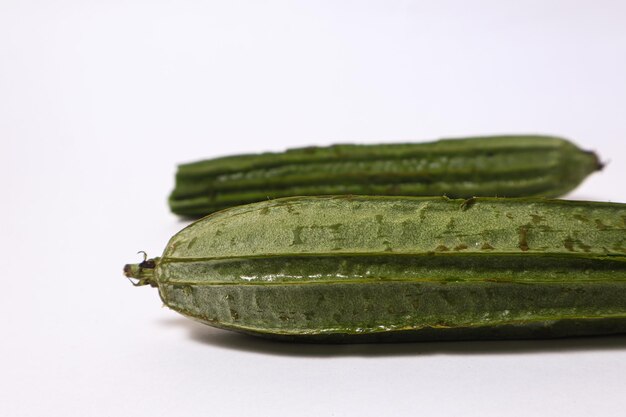 Frutas frescas de luffa em ângulo isoladas no fundo branco