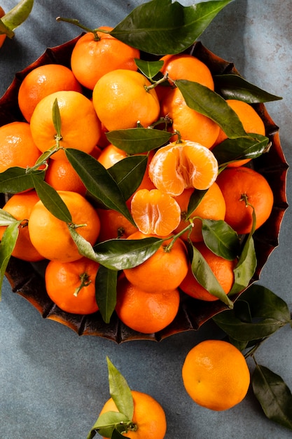 Frutas frescas de tangerina ou tangerinas com folhas em uma caixa de madeira, vista superior