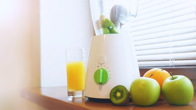 Frutas frescas e interior da cozinha e mesa de madeira - maçãs, kiwi, laranjas