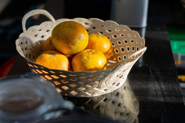 Frutas frescas e maduras de laranja sunkist servidas em cesta de vime