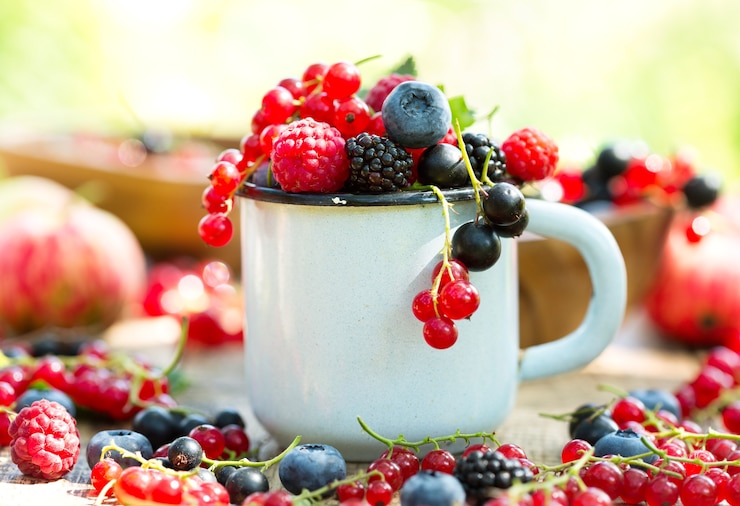 Foto frutas frescas em uma xícara na mesa de madeira
