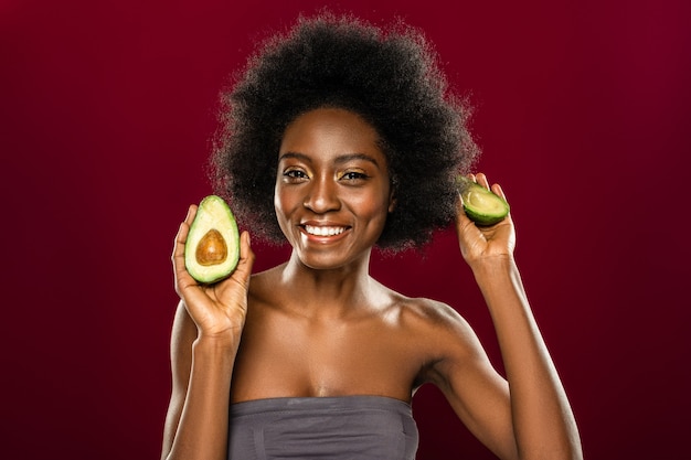 Frutas frescas. Encantado de mujer agradable sonriéndole mientras tiene una dieta saludable