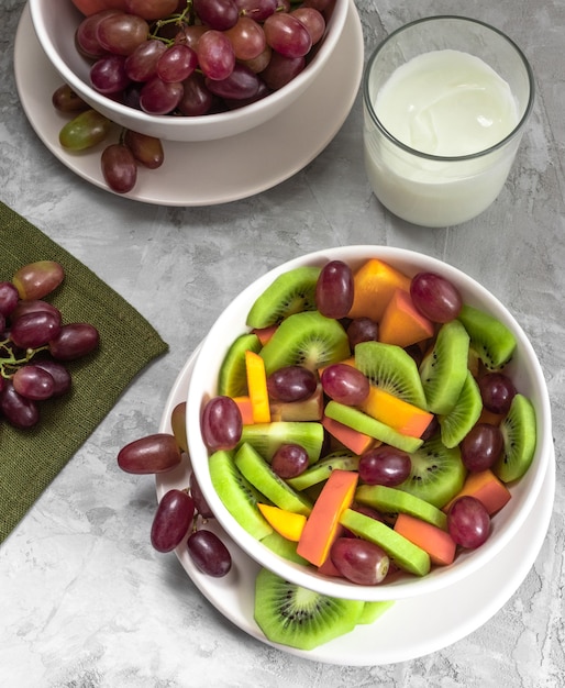 Foto frutas frescas fatiadas em salada com iogurte.