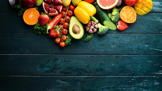 Frutas frescas, legumes e bagas. em um fundo preto. vista superior da bandeira. espaço livre para o seu texto.