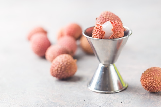 Frutas frescas de lichi sobre fondo gris sobre un fondo de madera