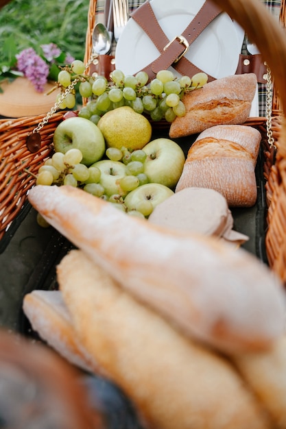 frutas frescas maçãs verdes uvas e pão de trigo crocante para um piquenique em família na natureza