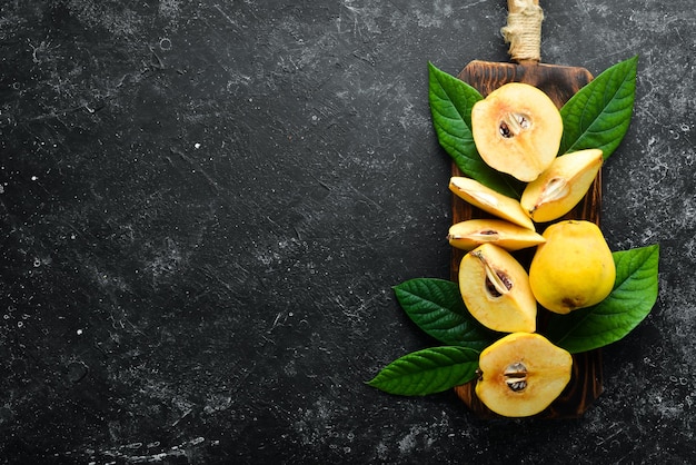 Frutas frescas de membrillo en una tabla de madera Vista superior Espacio libre para texto