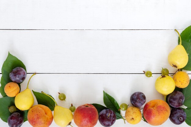 Frutas frescas en una mesa de madera blanca. Copie el espacio.