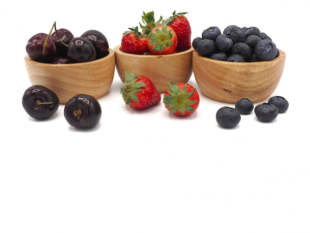 Frutas frescas no verão Morango cereja e mirtilo em tigela de madeira