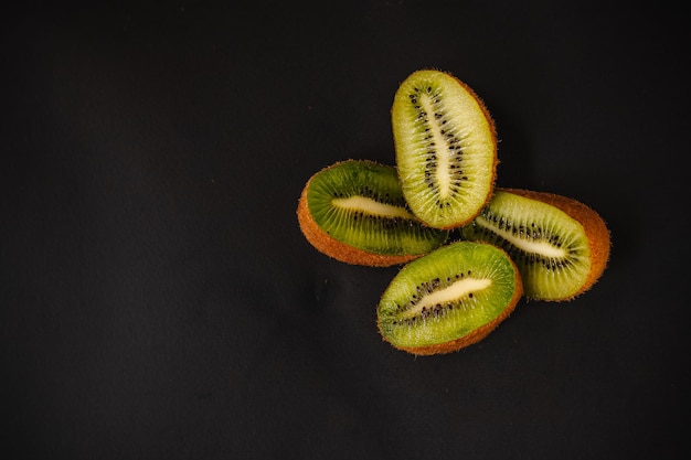 Frutas frescas sobre un fondo oscuro Naranja y kiwi en un corte aislado sobre un fondo negro Espacio de copia Producto de alta resolución