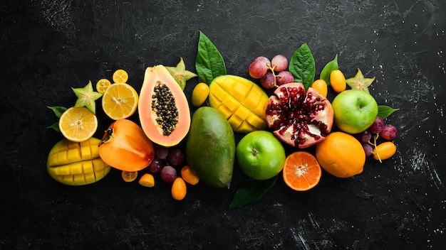 Frutas Frutas sazonais e tropicais em um fundo de pedra preta Fundo de comida Vista superior Espaço livre para o seu texto