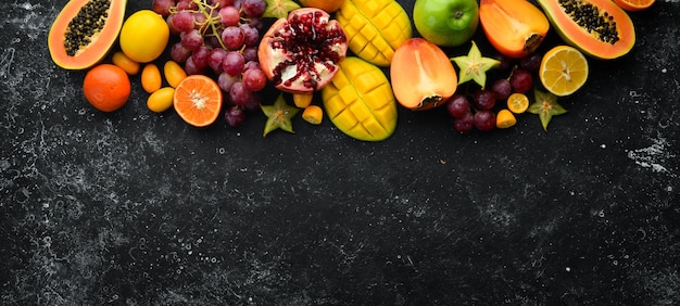 Frutas Frutas tropicales y de temporada sobre un fondo de piedra negra Fondo de alimentos Vista superior Espacio libre para el texto