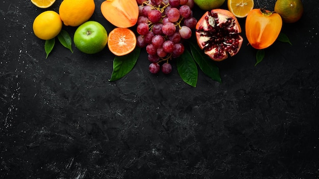 Frutas Frutas tropicales y de temporada sobre un fondo de piedra negra Fondo de alimentos Vista superior Espacio libre para el texto