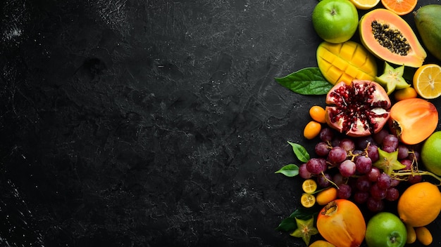 Frutas Frutas tropicales y de temporada sobre un fondo de piedra negra Fondo de alimentos Vista superior Espacio libre para el texto