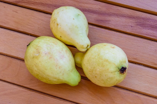 Frutas de guayaba amarillas maduras en la mesa de madera