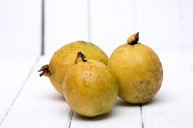 Frutas de guayaba frescas en un fondo blanco.