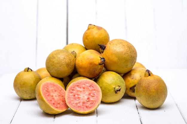 Frutas de guayaba frescas en un fondo blanco.