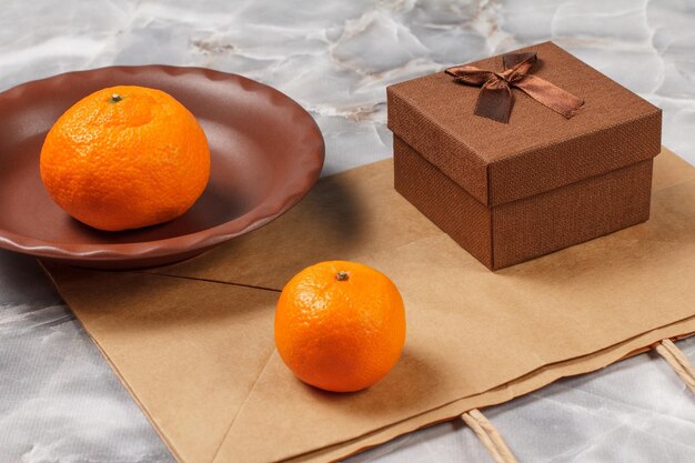 Frutas laranja e caixa de presente na mesa de pedra