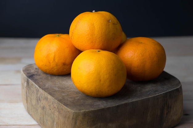 Frutas laranjas na tábua de cortar sobre a mesa