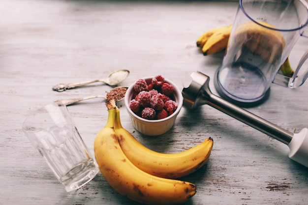 frutas y licuadora para hacer batidos e ingredientes sobre un fondo claro, vista superior