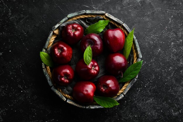 Frutas Maçãs vermelhas suculentas frescas Estilo rústico Em um fundo de pedra preta