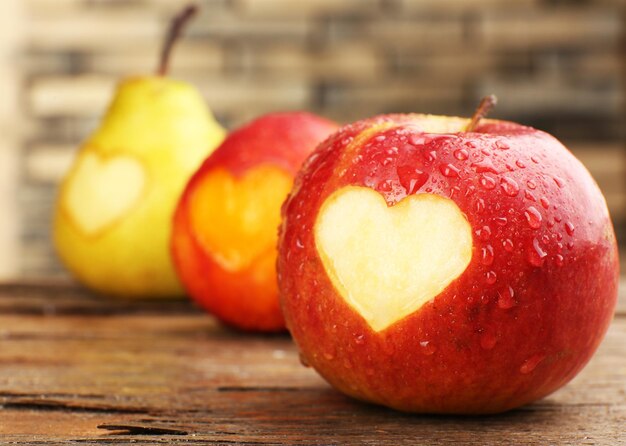 Frutas maduras com coração na mesa de madeira, close-up