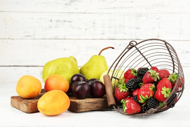 Foto frutas maduras e bagas na mesa sobre fundo de madeira