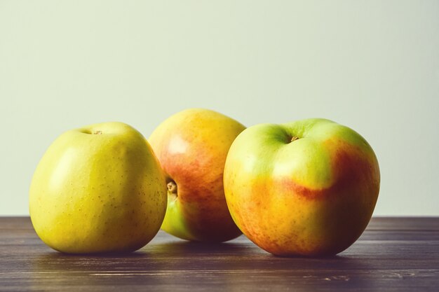 Foto frutas maduras, maçãs em uma velha mesa de madeira. fruta natureza morta