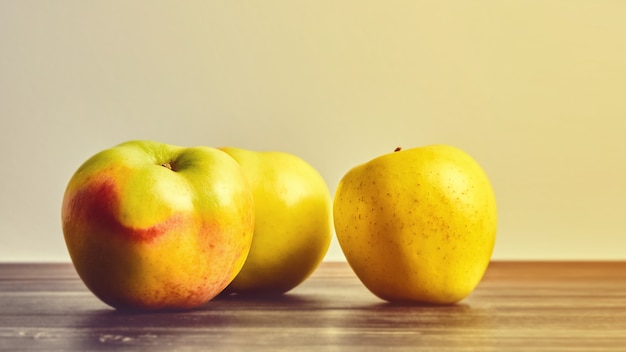 Foto frutas maduras, manzanas en una vieja mesa de madera. bodegón de frutas