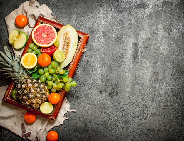 Frutas maduras na velha bandeja. sobre fundo rústico.