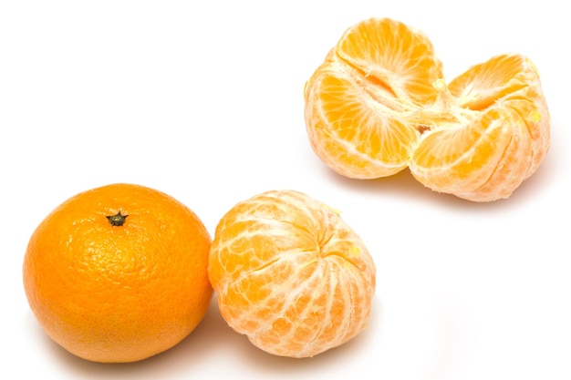 Frutas mandarinas maduras y frescas sobre fondo blanco.