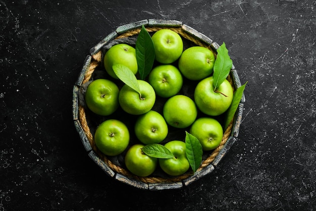 Frutas Manzanas verdes jugosas frescas en una bandeja Estilo rústico Sobre un fondo de piedra negra