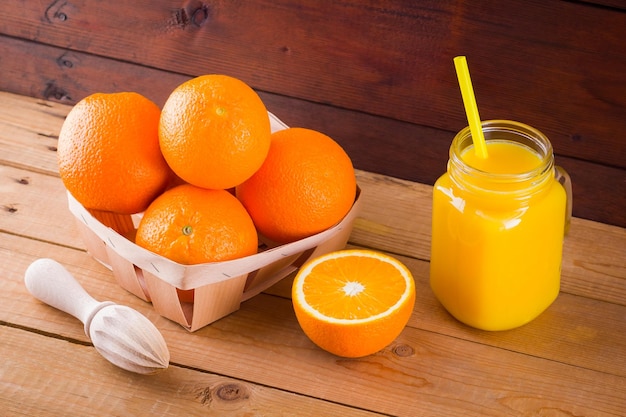 Frutas de naranja y jugo en tablas de madera Frutas cítricas para hacer jugo con exprimidor manual