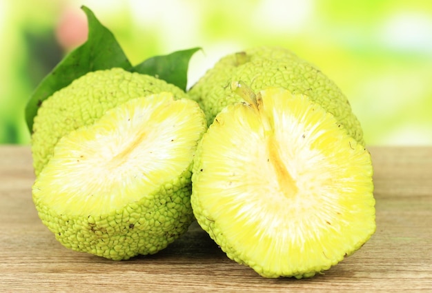 Frutas de naranja de Osage Maclura pomifera en una mesa de madera sobre un fondo natural