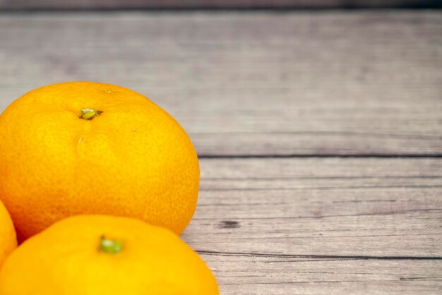 Foto frutas de naranja sobre un fondo de mesa de madera