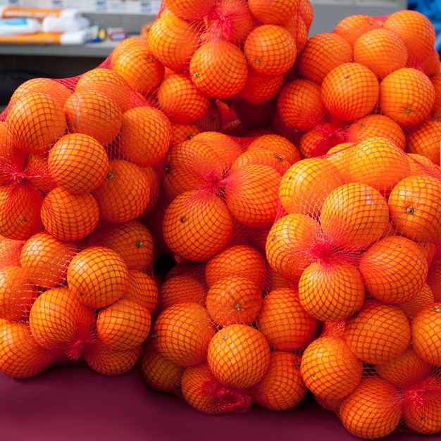 Frutas naranjas en bolsas netas de mercado